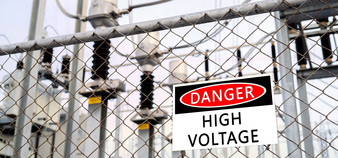 "danger hight voltage" sign against a wire fence